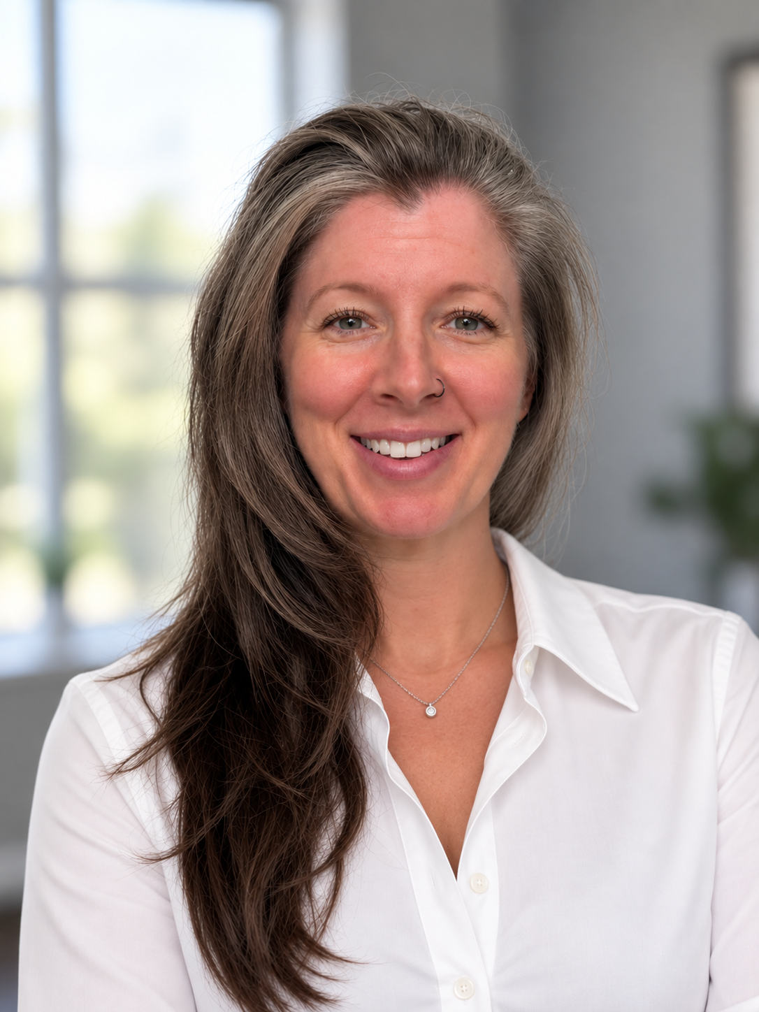 Professional portrait of Nikki Hines in a white collared shirt with a silver necklace